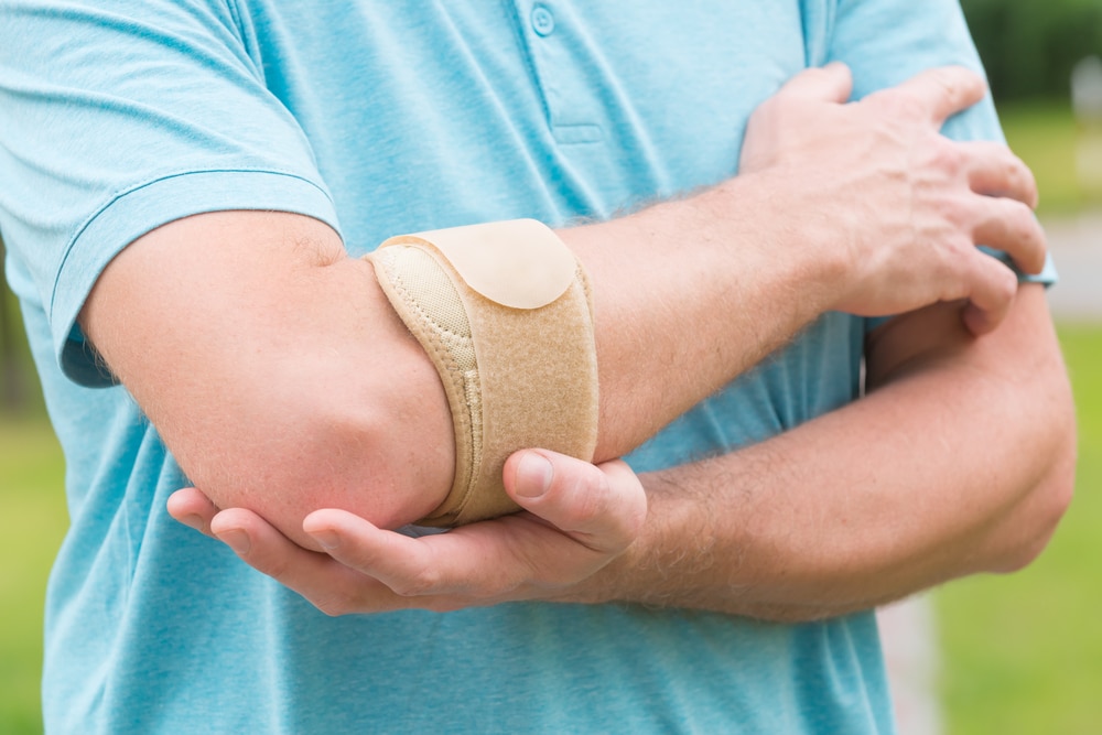 Man wearing elbow brace to reduce pain
